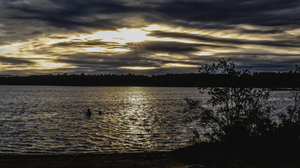 Sunset light shinning through clouds over lake
