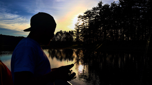 Silhouette of man fishing at dawn