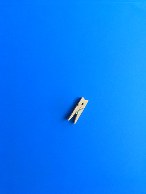 Small laundry tong on blue background