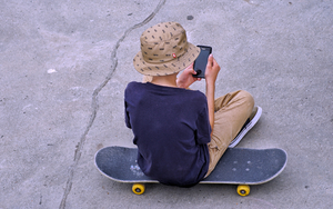 A boy using a smartphone in a skatepark