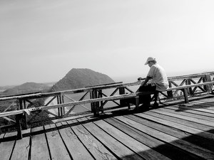 Man drinking coffee on a bridge