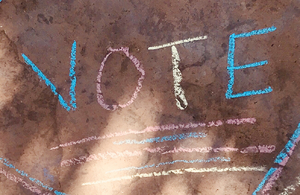 Vote written with sidewalk chalk on the pavement