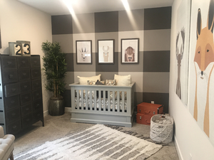 A child’s room with a crib and stripes on the walls