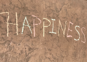 The word happiness written with sidewalk chalk