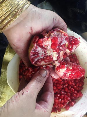 woman peels off Pomegranate