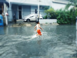 Boy running in flood street