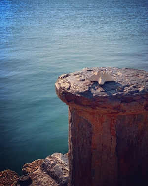 Rusty iron pylon on sea side