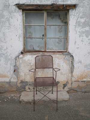 Distressed window and rusted chair