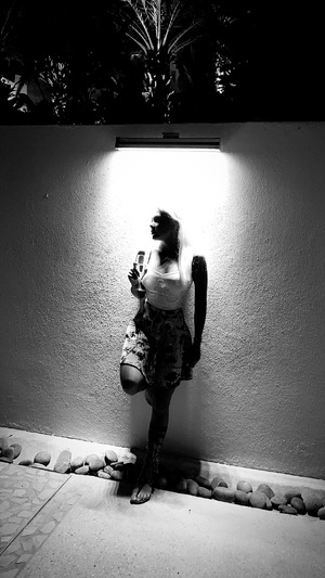 woman leaning against wall at night