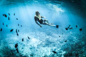 Scuba diver underwater with fish