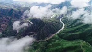 Green valley with river and clouds from above