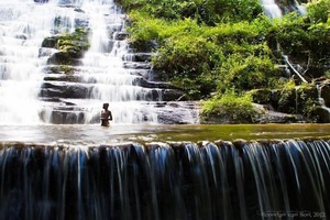 Woman standing in waterfall