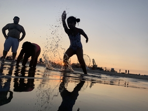 Child playing in water on beach during sunset