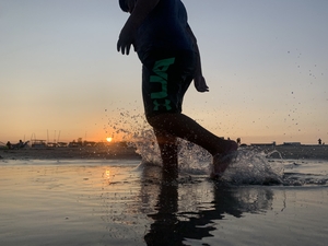 Walking through water at sunset at the coast