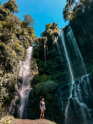 Man standing in fron of waterfall.
