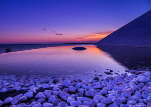 Beautiful blend of a purple sunset and white pebbles along lake