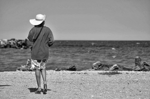 Woman with summer hat looking at the sea