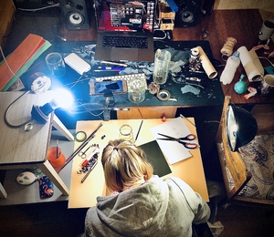 girl crafting handmade toys on her desk