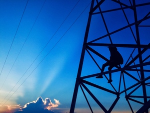 Boy sitting in electricity pole