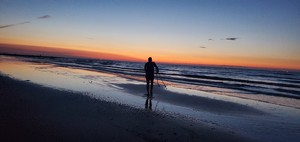 Man walking on beach during sunset