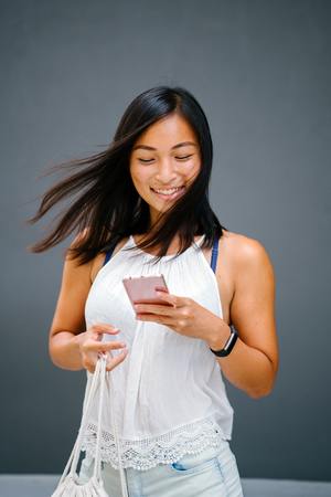 Smiling black young lady looking at mobile