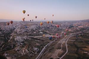 Long shot of various multi-colored hot air balloons floating in the sky