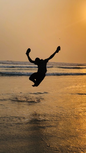 Happy man jumping in sea
