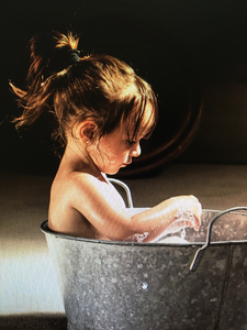 Little girl sitting in sink tub