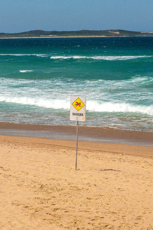 Cronulla beach with a danger sign