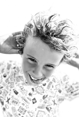 black and white portrait of young smiling boy at the beach