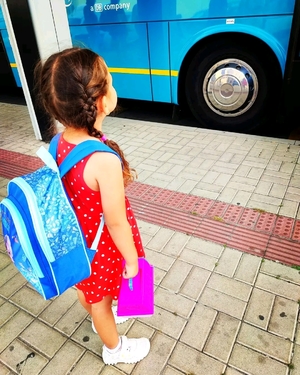 A little girl watches the buses at the station
