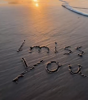 Text I miss you in sand on beach