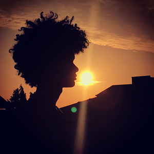 Silhouette of head of woman against sky during sunset