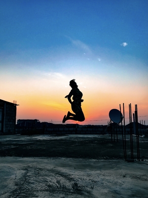 girl jumping during a sunset