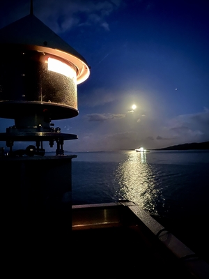 lighthouse flashing with ship and moon – edit