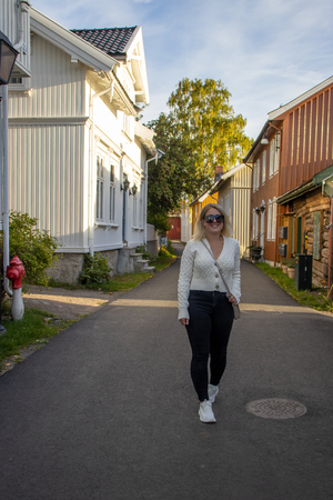 Woma with sunglasses walking through village in Norway