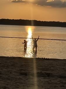 mother and daughter playing in water silhouettes