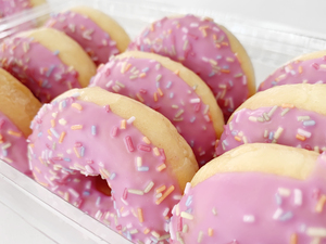 pink freshly prepared donuts in box