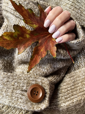 autumn maple leaf in hand with manicure