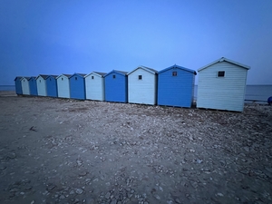 Blue and white beach huts at charmouth