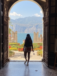 Woman walking through arch doorway Garda lake Italy
