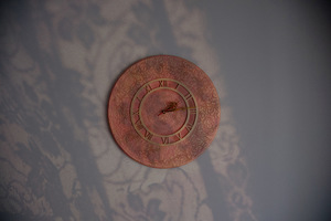 A wall clock and the shadow of lace curtain