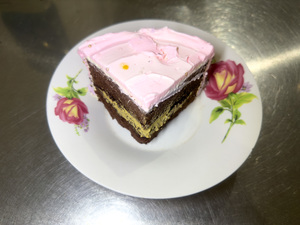 slice of cake with pink cream served on white plate