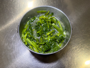 vegetable stir fried water spinach on stainless bowl