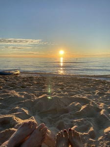 Close up of feet on beach at sunset Lake Michigan
