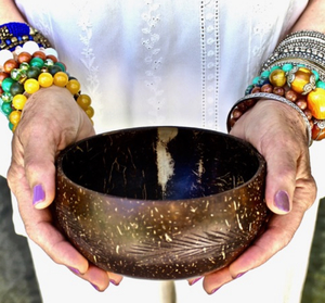 Two hands holding a wooden bowl