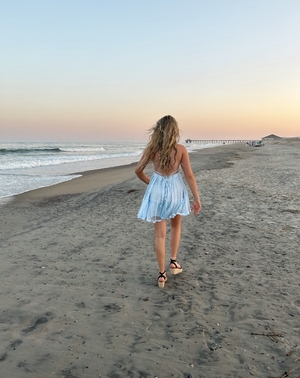 Backview of blonde woman walking on the beach