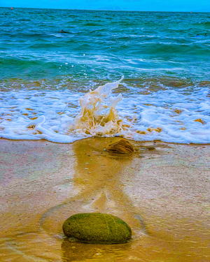 ocean wave splashing a stone